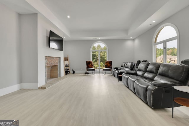 living room with light wood-type flooring and a brick fireplace