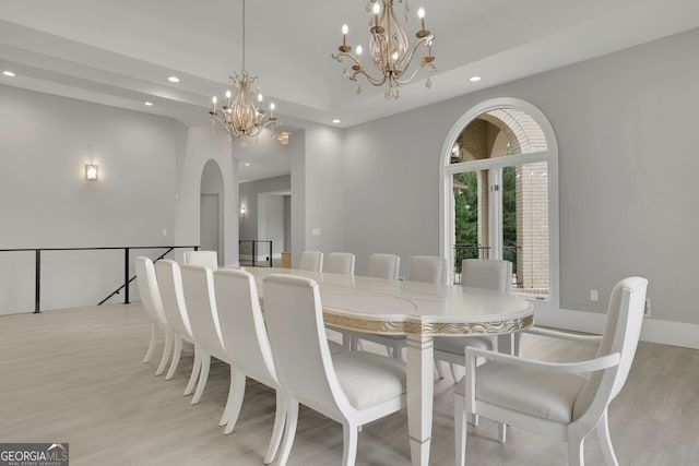 dining space featuring light hardwood / wood-style flooring and a notable chandelier