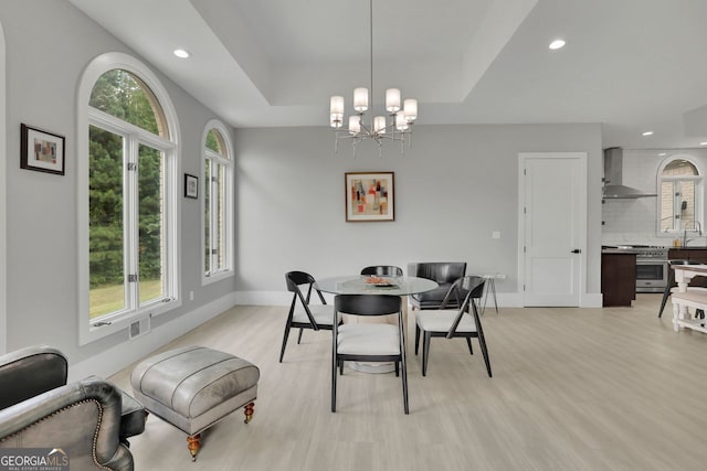 dining room with light hardwood / wood-style floors and an inviting chandelier