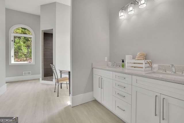 bathroom with hardwood / wood-style floors, vanity, and walk in shower