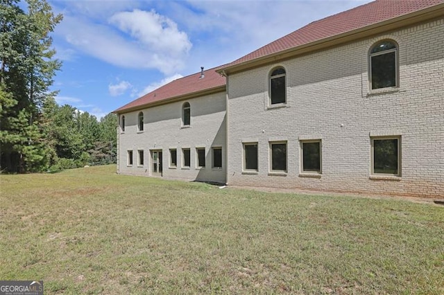 back of house with a lawn