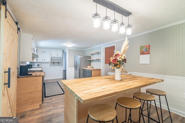 kitchen featuring a barn door, white cabinetry, dark wood-type flooring, and stainless steel refrigerator with ice dispenser