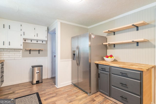 kitchen featuring tasteful backsplash, white cabinetry, stainless steel refrigerator with ice dispenser, and light wood-type flooring