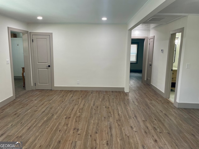 empty room featuring ornamental molding and hardwood / wood-style floors