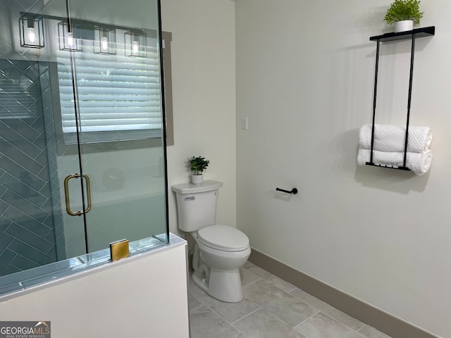 bathroom featuring tile patterned flooring, a shower with shower door, and toilet