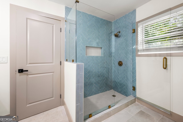 bathroom with a shower with door and tile patterned floors