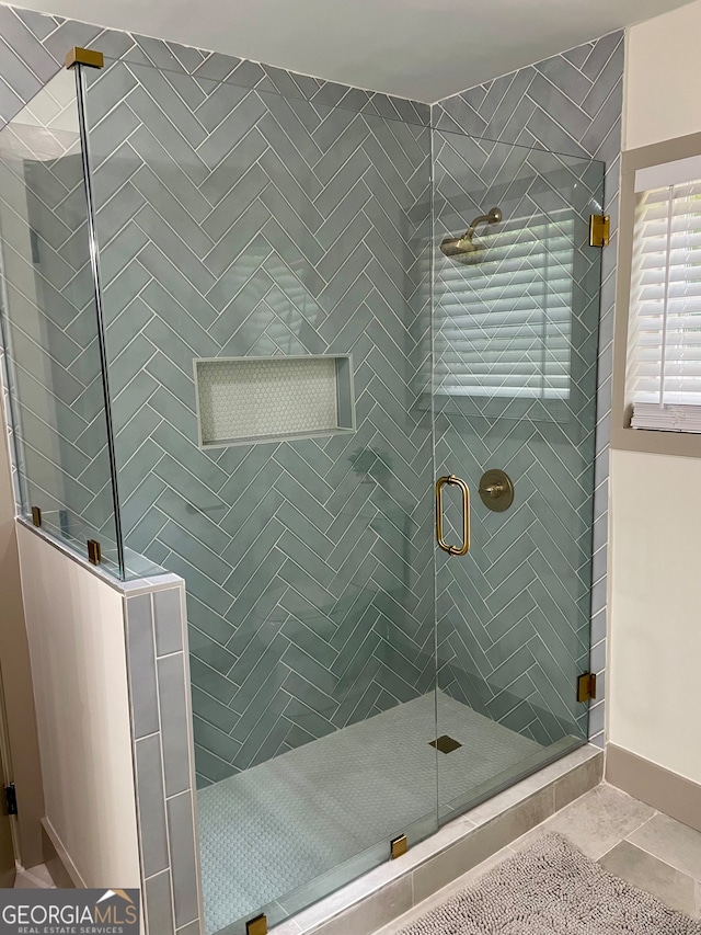 bathroom featuring a shower with door and tile patterned floors