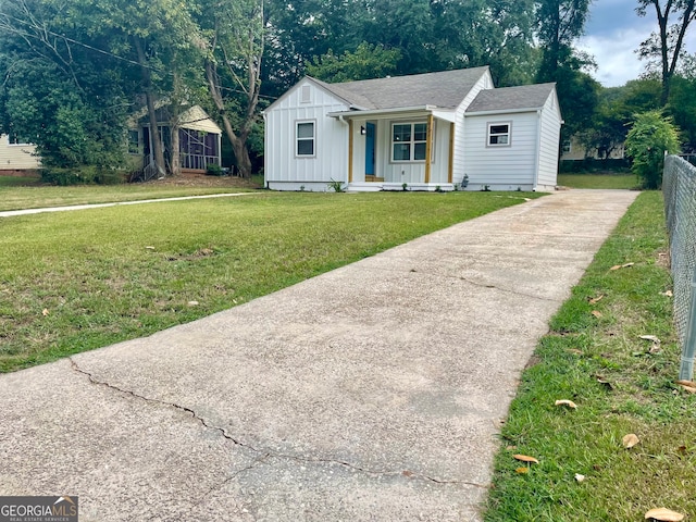 ranch-style home featuring covered porch and a front yard