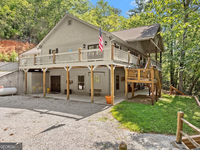 back of property with a wooden deck, a patio, a yard, and stairway