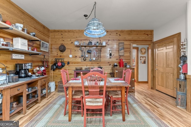 dining room with wooden walls and wood finished floors