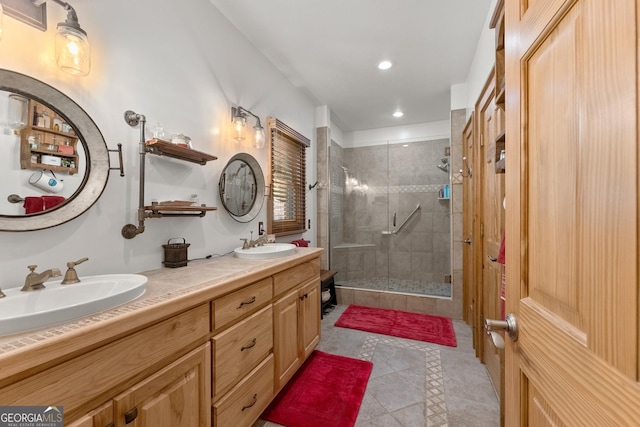 bathroom with a shower stall, recessed lighting, double vanity, and a sink