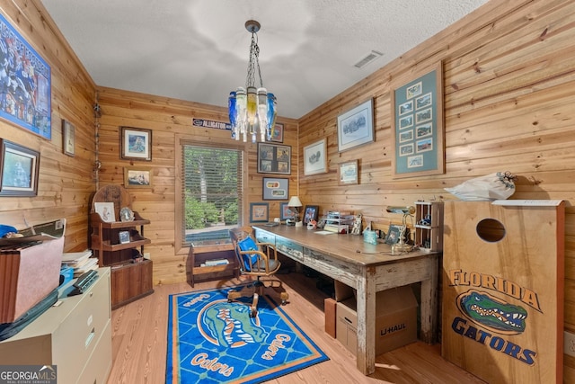 office space featuring visible vents, a textured ceiling, an inviting chandelier, and wood finished floors