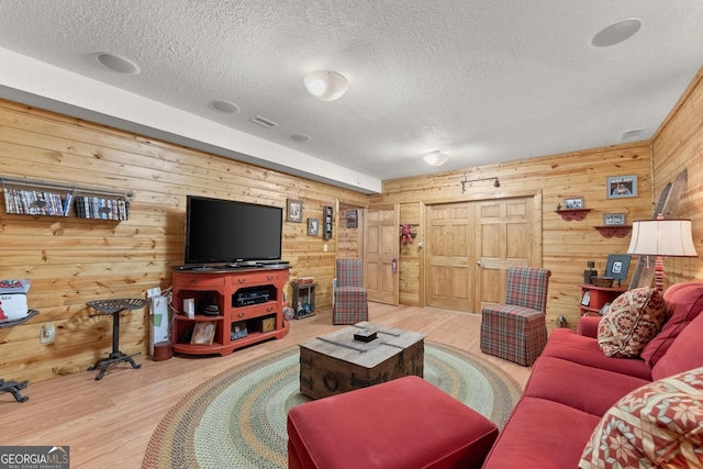 living room with visible vents, a textured ceiling, and wood finished floors