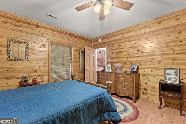 bedroom with visible vents, a textured ceiling, ceiling fan, and wood finished floors