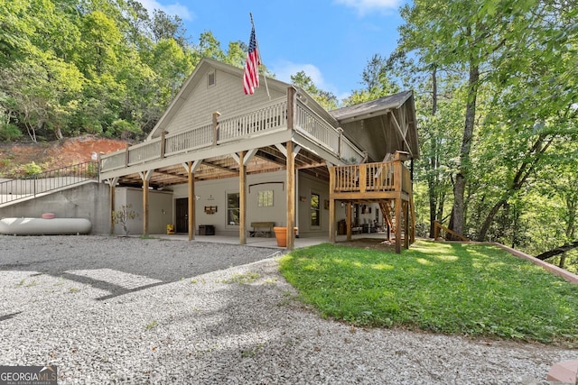 exterior space with a wooden deck, a patio, and a front yard