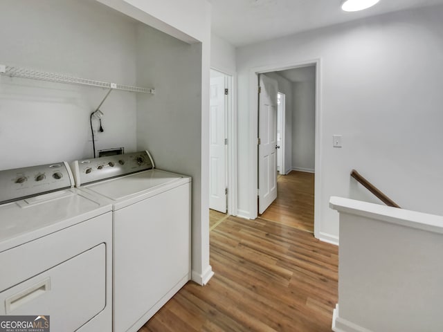 laundry room with light hardwood / wood-style floors and washing machine and clothes dryer