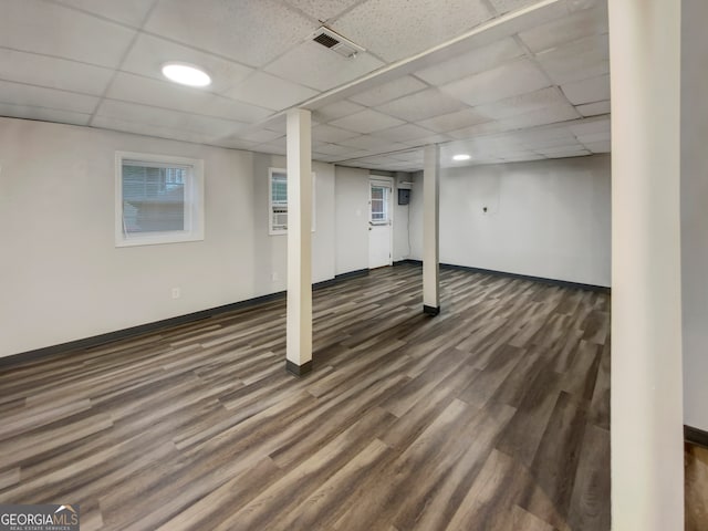 basement with a drop ceiling and dark hardwood / wood-style floors