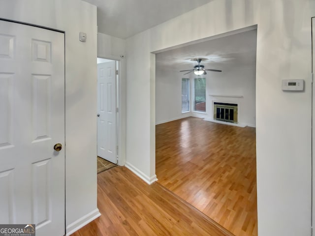 unfurnished living room featuring ceiling fan and hardwood / wood-style flooring