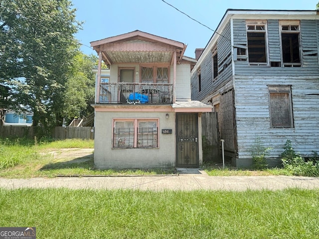 exterior space with a balcony and a front yard