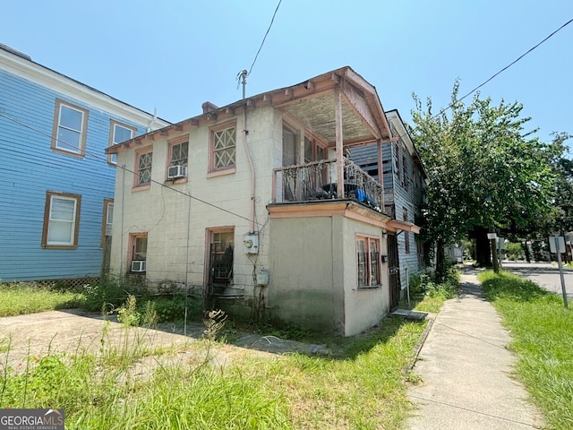 rear view of house featuring cooling unit and a balcony