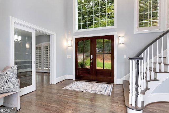 entryway with french doors, dark hardwood / wood-style floors, and a high ceiling