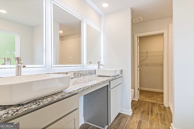 bathroom with hardwood / wood-style floors, vanity, and toilet