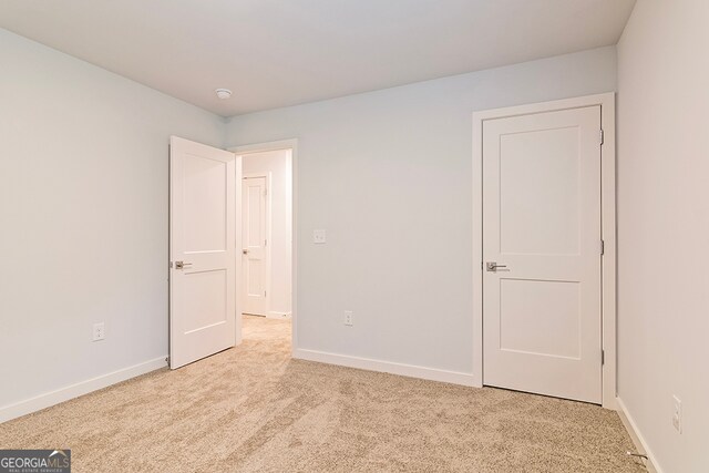 unfurnished bedroom featuring light carpet