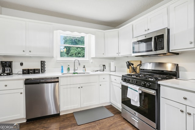 kitchen with white cabinets, sink, a textured ceiling, stainless steel appliances, and dark hardwood / wood-style floors