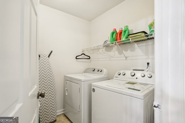 washroom with washer and dryer and a textured ceiling