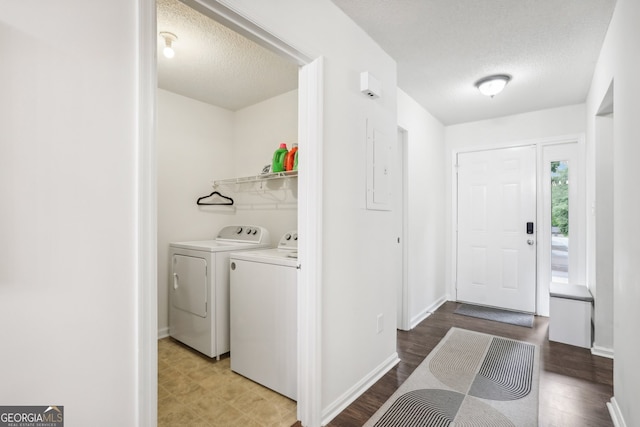 laundry room featuring washing machine and dryer, hardwood / wood-style floors, and a textured ceiling