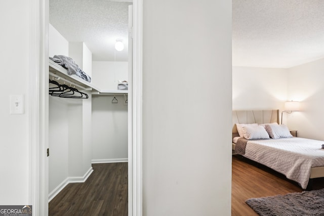 bedroom with a textured ceiling and dark hardwood / wood-style floors