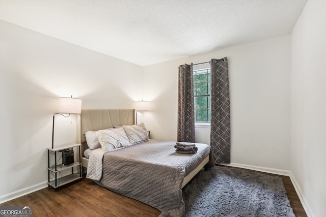 bedroom featuring dark hardwood / wood-style floors and a textured ceiling