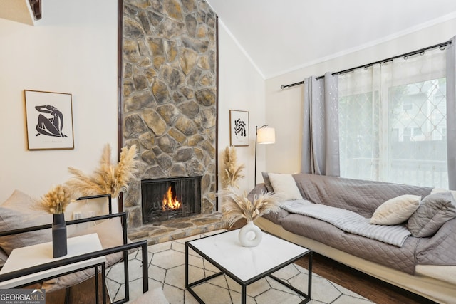 living room with wood-type flooring, a stone fireplace, lofted ceiling, and ornamental molding