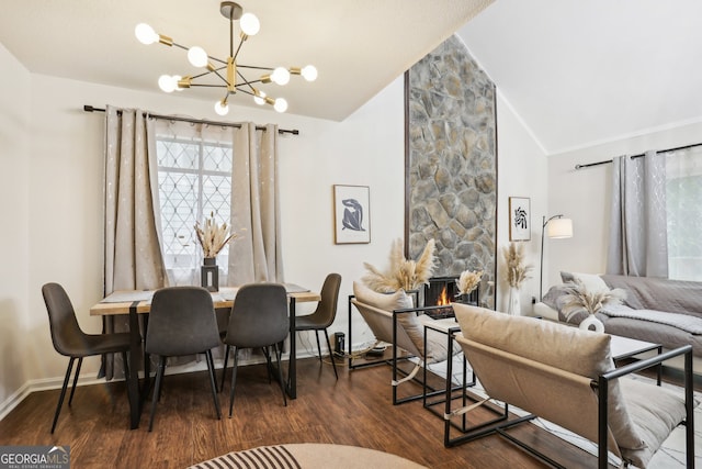 dining room with a chandelier, crown molding, dark wood-type flooring, lofted ceiling, and a fireplace