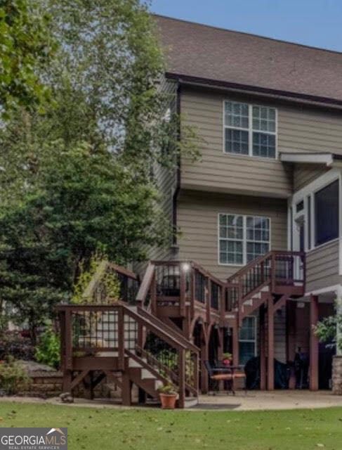 rear view of property with a patio, a deck, and a lawn