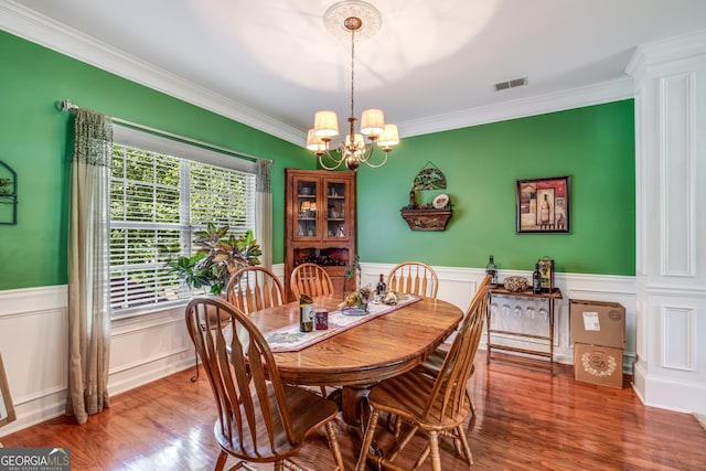 dining room featuring ornamental molding, a chandelier, and hardwood / wood-style flooring