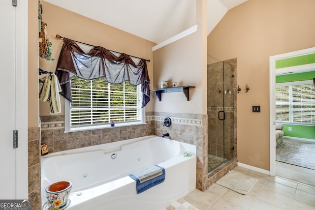 bathroom featuring plus walk in shower, vaulted ceiling, a healthy amount of sunlight, and tile patterned floors