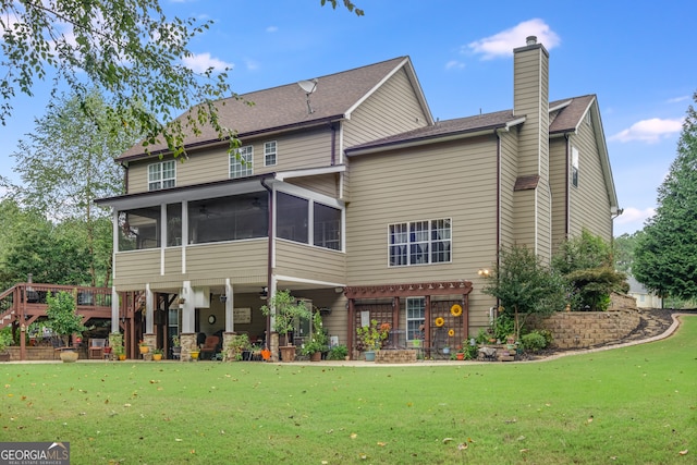 back of property with a sunroom and a lawn