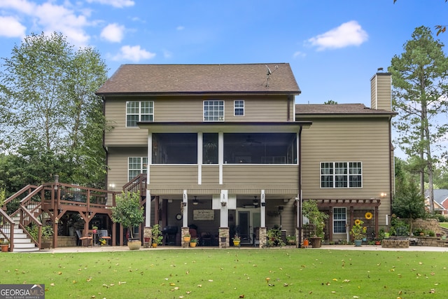 back of house featuring a deck, a sunroom, a yard, and a patio area