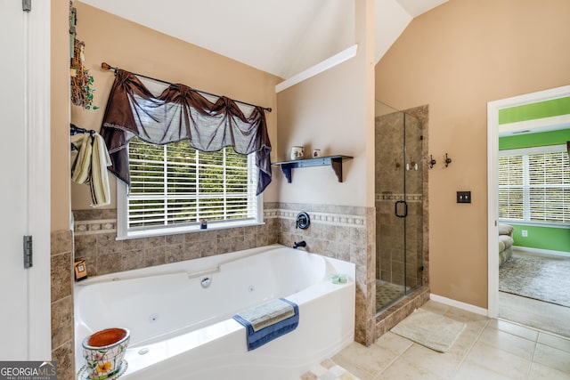 bathroom featuring a jetted tub, a shower stall, tile patterned floors, baseboards, and lofted ceiling