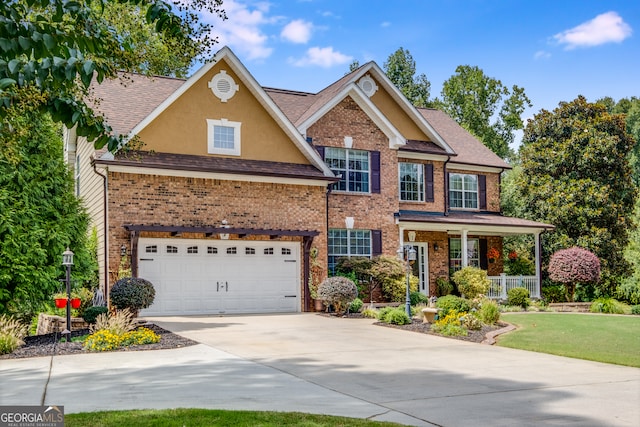 view of front of house with a porch, a garage, and a front lawn