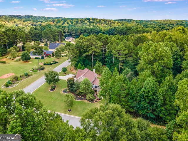 bird's eye view with a wooded view