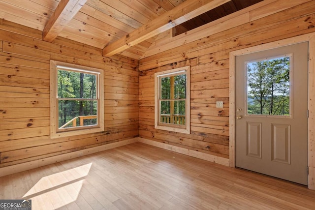 interior space with beamed ceiling, light hardwood / wood-style flooring, wooden walls, and wooden ceiling