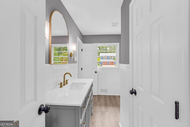 bathroom featuring tile walls, vanity, and hardwood / wood-style floors