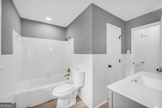 full bathroom featuring vanity, shower / bathtub combination, hardwood / wood-style flooring, tile walls, and toilet