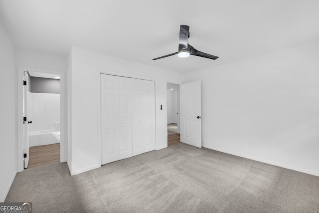 unfurnished bedroom featuring ceiling fan, ensuite bath, a closet, and light carpet