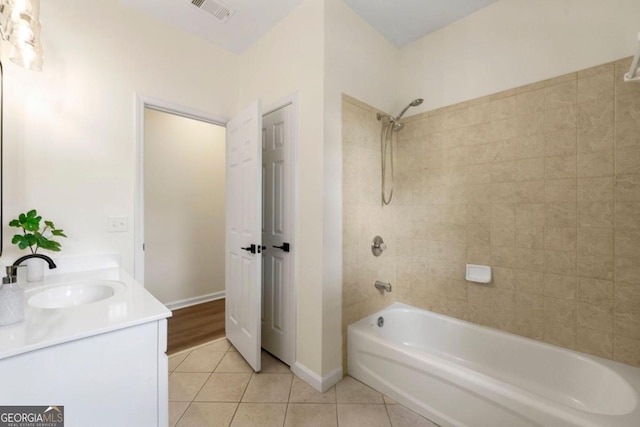 bathroom featuring tile patterned flooring, vanity, and tiled shower / bath combo