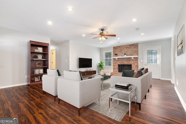 living room with a brick fireplace, plenty of natural light, and dark hardwood / wood-style floors