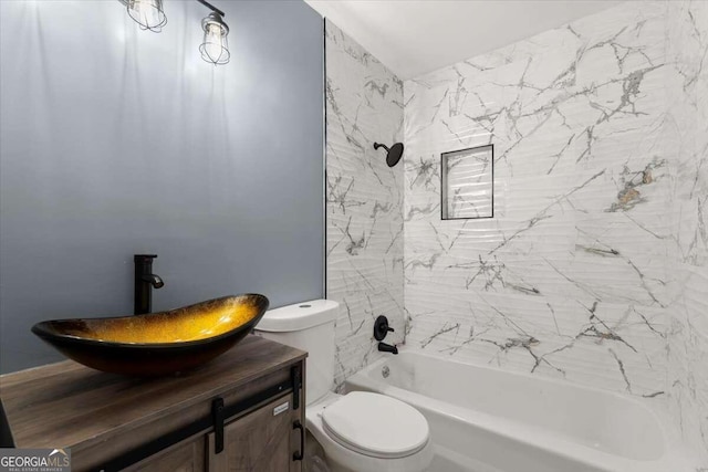 full bathroom featuring tiled shower / bath, vanity, and toilet