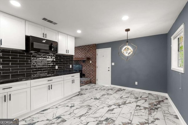 kitchen with decorative light fixtures, backsplash, and white cabinetry